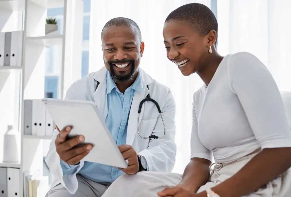 Doctor, healthcare and medicine with a patient talking test results and progress on a tablet in a hospital clinic