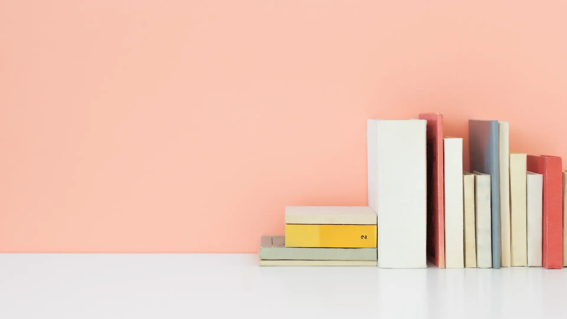 A collection of journals on a pink background